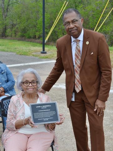 Alexandria Mayor Jeff Hall presents a plaque to Winnie Marshall, wife of late City Councilman Louis J. Marshall, Tuesday morning at a dedication ceremony naming a bike/walking trail in Marshall’s honor.