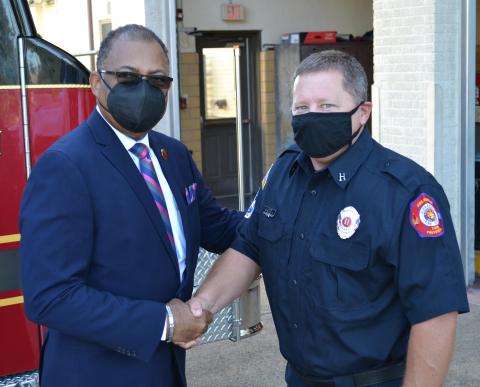 Alexandria Mayor Jeff Hall (left) shakes hands with City of Alexandria Local 540 Fire Fighters Association Union representative Shane Saizan Tuesday morning. The Mayor and union announced that they have reached an agreement on a new contract that will provide the first increase in base pay since 2008.