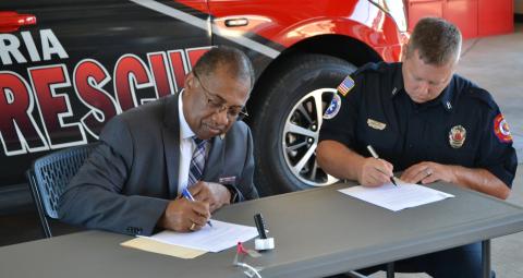 Mayor Jeffrey W. Hall (left) and City of Alexandria Local 540 Fire Fighters Association Union President Shane Saizan formally sign the contract between the City and the union during a ceremony Thursday morning at Fire Station No. 5 on Coliseum Blvd. 
